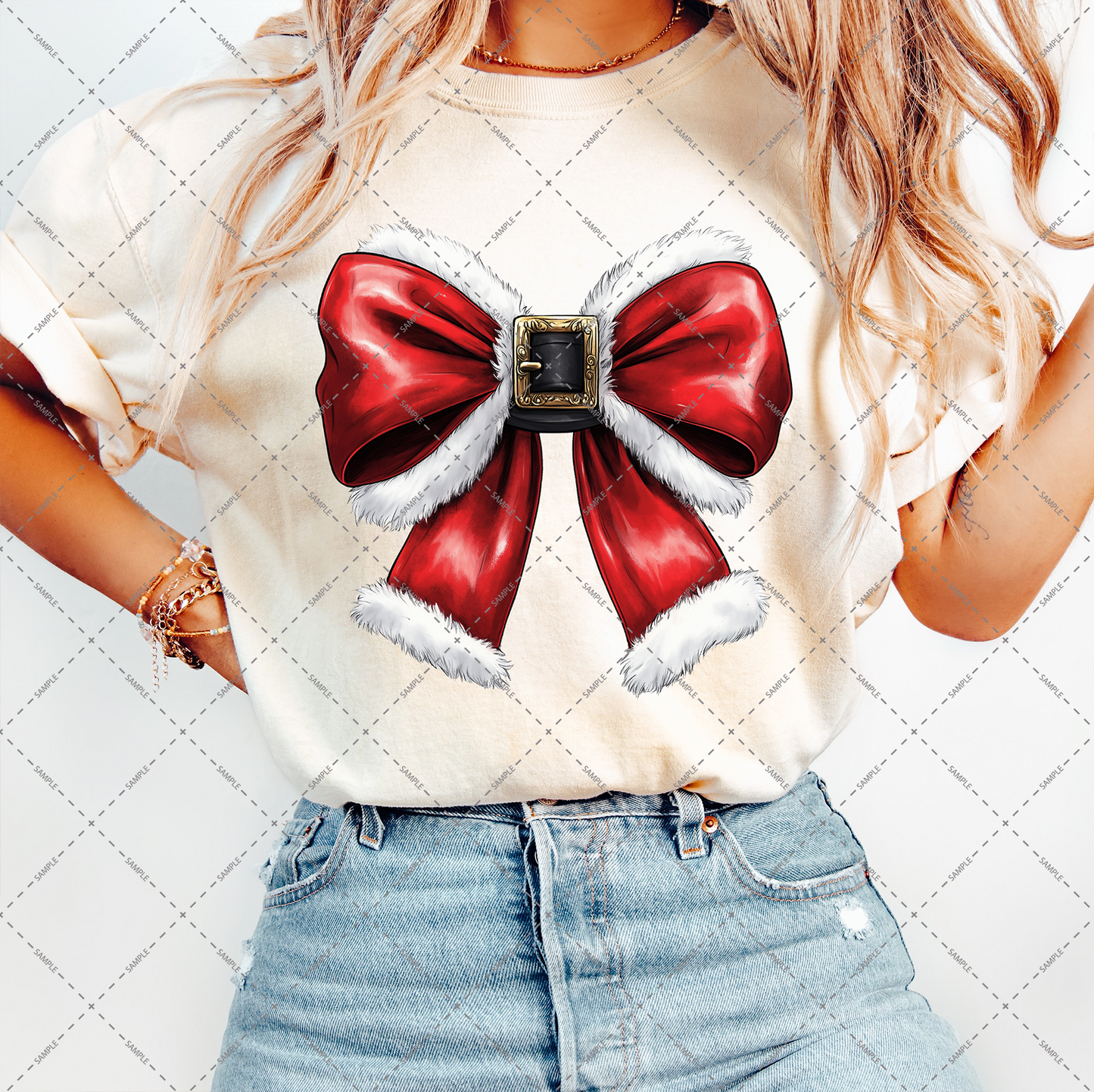 A person in a beige T-shirt adorned with a prominent red bow trimmed with white fur and featuring a decorative buckle is matched with light blue jeans. Their long, wavy hair adds harmony to the ensemble as they pose against the transparent background of the Christmas Coquette Bow PNG file.